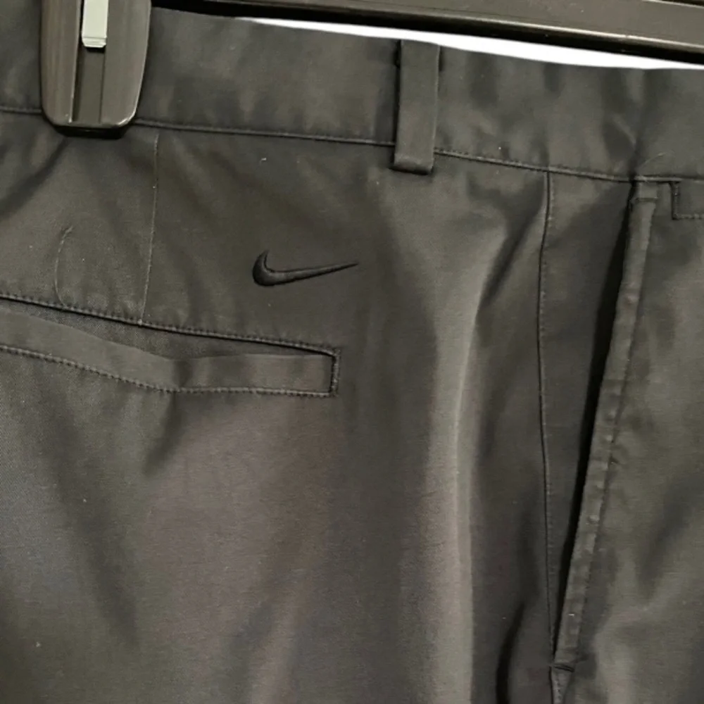 Nike Golf Tour Performance Dri-Fit black golf pants. Flat front Nike logo 40/26